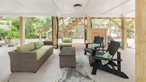 An outdoor patio area with a sofa, chairs, and a small table. - DOG FRIENDLY - Second Row ...Ruff Life beach cottage. (Oak Island)