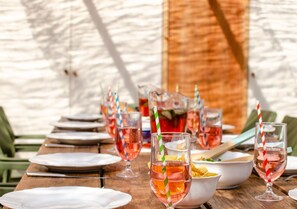 Enjoy a casual meal under the stars at this outdoor dining area, complete with a rustic table set and a selection of snacks.