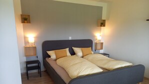 Een slaapkamer met een bed, twee nachtkastjes en twee wandlampen.