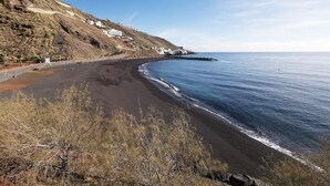 A coastal landscape with a curved sandy beach, rocky terrain, and sparse vegetation. - Home2Book Sea Views Tabaiba, Wifi & Terrace (Tabaiba)