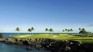 A coastal golf course with a clear view of the ocean, palm trees, and a rocky shoreline. - Sophisticated freshly remodeled 3bd+/3ba, two story villa w/ Private Beach club (Puako)