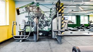 A gym with exercise equipment, a mural, and a yellow wall. - YOUNIQ Gdansk - Campus Accommodation (Gdansk)
