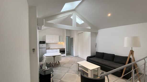 A modern apartment with a kitchen, dining area, and living room.