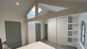 A bedroom with a bed, a wardrobe, and a skylight.
