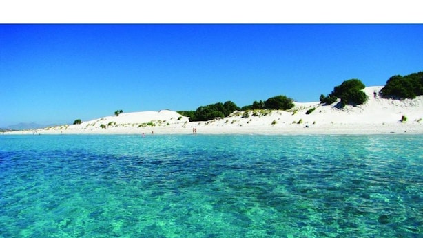 Uma praia com águas azul-turquesa e areia branca.
