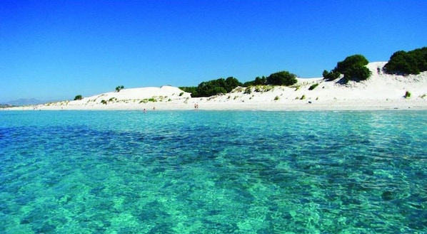 A beach with clear turquoise water and white sand.