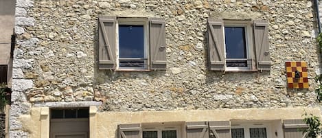A stone building with multiple windows and a door.