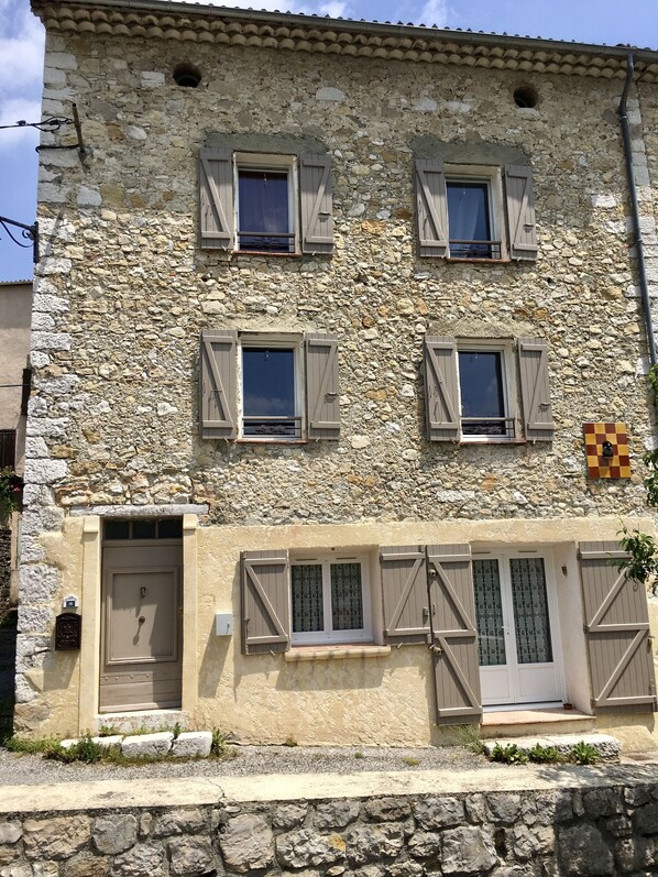 A stone building with multiple windows and a door.