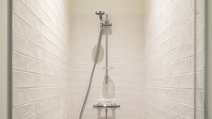 A modern shower with a handheld showerhead and a fixed showerhead mounted on the wall. - Le Moulin des Carmélites 1 - Appt moderne à Rennes (Rennes)