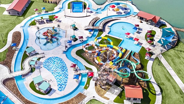 Vue aérienne d’un parc aquatique avec de nombreux toboggans, une piscine et des aires de pique-nique.