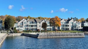 A waterfront residential building with multiple balconies, a dock, and a clear view of the water.