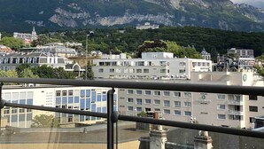 A cityscape with buildings and mountains in the background. - Modern studio with breathtaking view close to the train station (Aix-les-Bains)