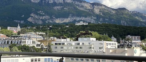 A cityscape with buildings and mountains in the background.