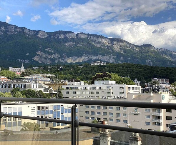 A cityscape with buildings and mountains in the background.