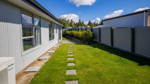 A row of modern mobile homes with a well-maintained lawn and stone pathway. - Remarkable  Rhoboro Retreat (Twizel)
