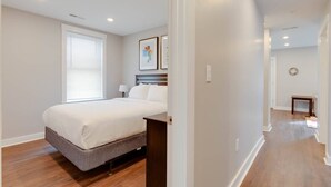 A bedroom with a bed, a bedside table, a lamp, and a window with blinds. - 3 Bed 2 Bath Tourist House near Kendall Square (Cambridge)