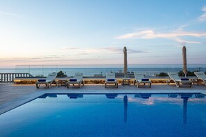 A poolside area with lounge chairs and a view of the sea. - Agapi Villa II, a Seaside Retreat with Pool & BBQ, Walking distance to beach (Rethymno)