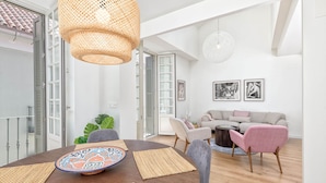Un comedor con una mesa redonda, individuales tejidos y un plato decorativo.