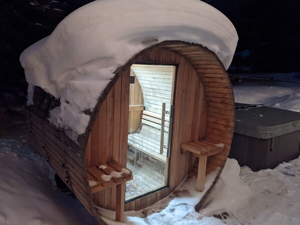 Eine Holz-Blockhütte mit verschneitem Eingang und einem kleinen Fenster.