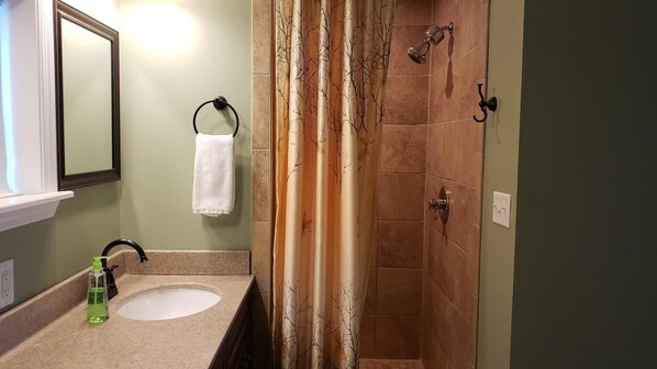 A bathroom with a sink, mirror, towel rack, shower curtain, and shower door. - The Salty Siren- Steinhatchee Landing Resort Sleeps 9 -New High Speed Internet (Steinhatchee)