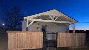 Un petit bâtiment d’un seul étage, doté d’un porche couvert et d’une entrée fermée par un portail.