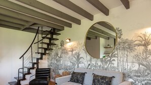 A staircase with a metal railing, a round mirror, and a wall with a tropical mural. - L'Atelier de La Maison Saint Léonard | pretty shared garden honfleur center (Honfleur)