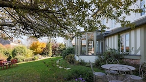 Un jardin doté d’un patio, d’une véranda et offrant une vue sur une maison.