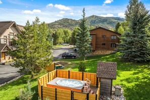 Un quartier résidentiel avec des maisons, un jacuzzi et une vue sur les montagnes en toile de fond.