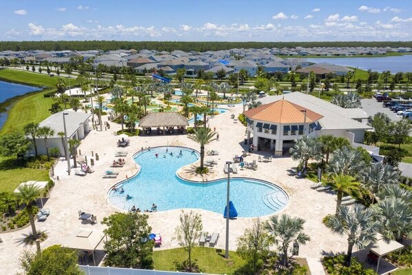 A resort with multiple swimming pools, a large central pool, and a water slide.