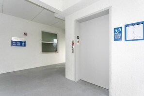 Pasillo con un cartel que indica el primer piso y el plano de evacuación de emergencia.