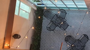 A room with a patterned wall, a window, and string lights.