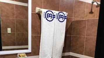 A bathroom with a white sink, toilet, and a towel rack with two towels.