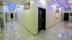 A hallway with a marble floor, blue LED lighting, and a door with a keycard lock. - Princess Paradise Suites-Asaba Delta (Asaba)