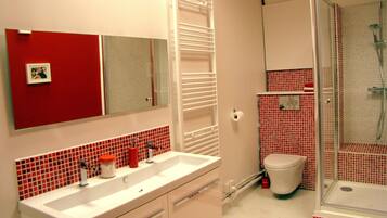 Een bad/douchecombinatie, een haardroger, zeep, toiletpapier