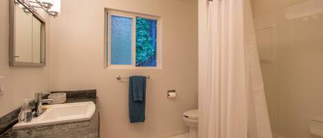 A bathroom with a sink, toilet, and shower curtain.