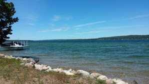 Blick auf ein Seeufer mit Steg und Boot.