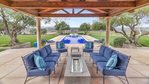 An outdoor patio with a covered seating area, a pool, and a view of the landscape. - Luxury Villa: Pool, Hot Tub, Pickleball, Ping-Pong & Bocce. 10 min to downtown! (Paso Robles)