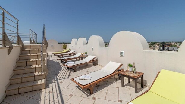 A rooftop terrace with sun loungers, a small table with drinks, and a staircase. - BT Vent de Garbi (Castello d'Empuries)