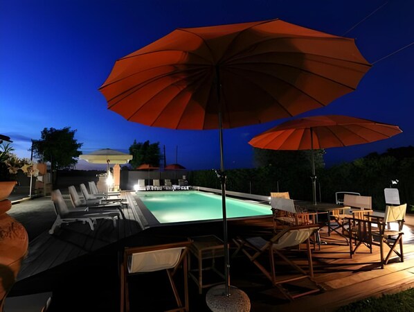 An outdoor swimming pool area with lounge chairs and umbrellas. - Agriturismo Le Due Ruote (Grosseto)
