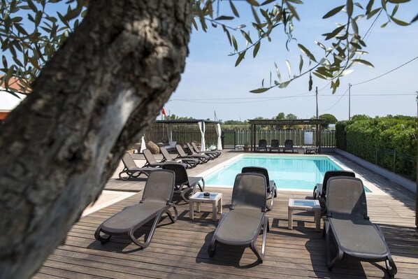 A poolside area with lounge chairs and a swimming pool. - Agriturismo Le Due Ruote (Grosseto)