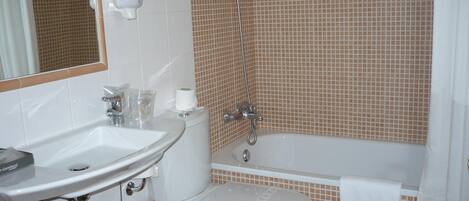 A bathroom with a sink, toilet, and bathtub.