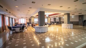 A spacious hotel lobby with multiple seating areas, including round tables and a central column. - Hotel ATH Al Medina Wellness (Medina-Sidonia)