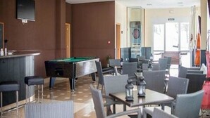A billiards table, bar area, and seating arrangement in a well-lit indoor space. - Hotel ATH Al Medina Wellness (Medina-Sidonia)