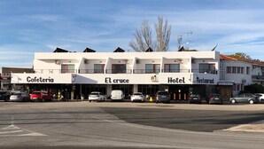 A building with a 'Cafeteria,' 'El cruce,' 'Hotel,' and 'Restaurant' on the ground floor. - El Cruce (Manzanares)