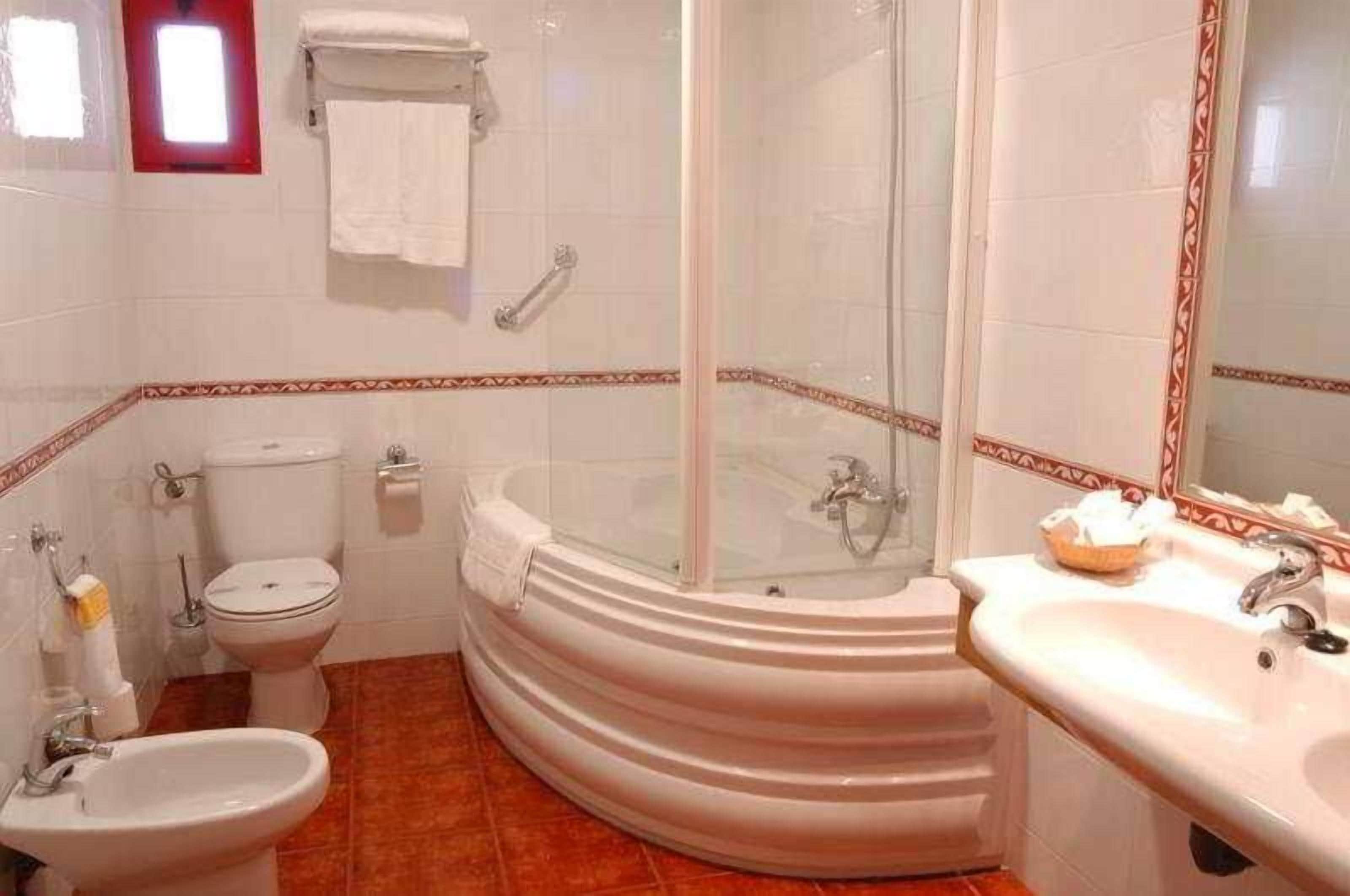 Un bany amb banyera, v àter, bidet i rentapel.