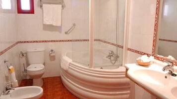 Un bany amb banyera, vàter, bidet i rentapel.