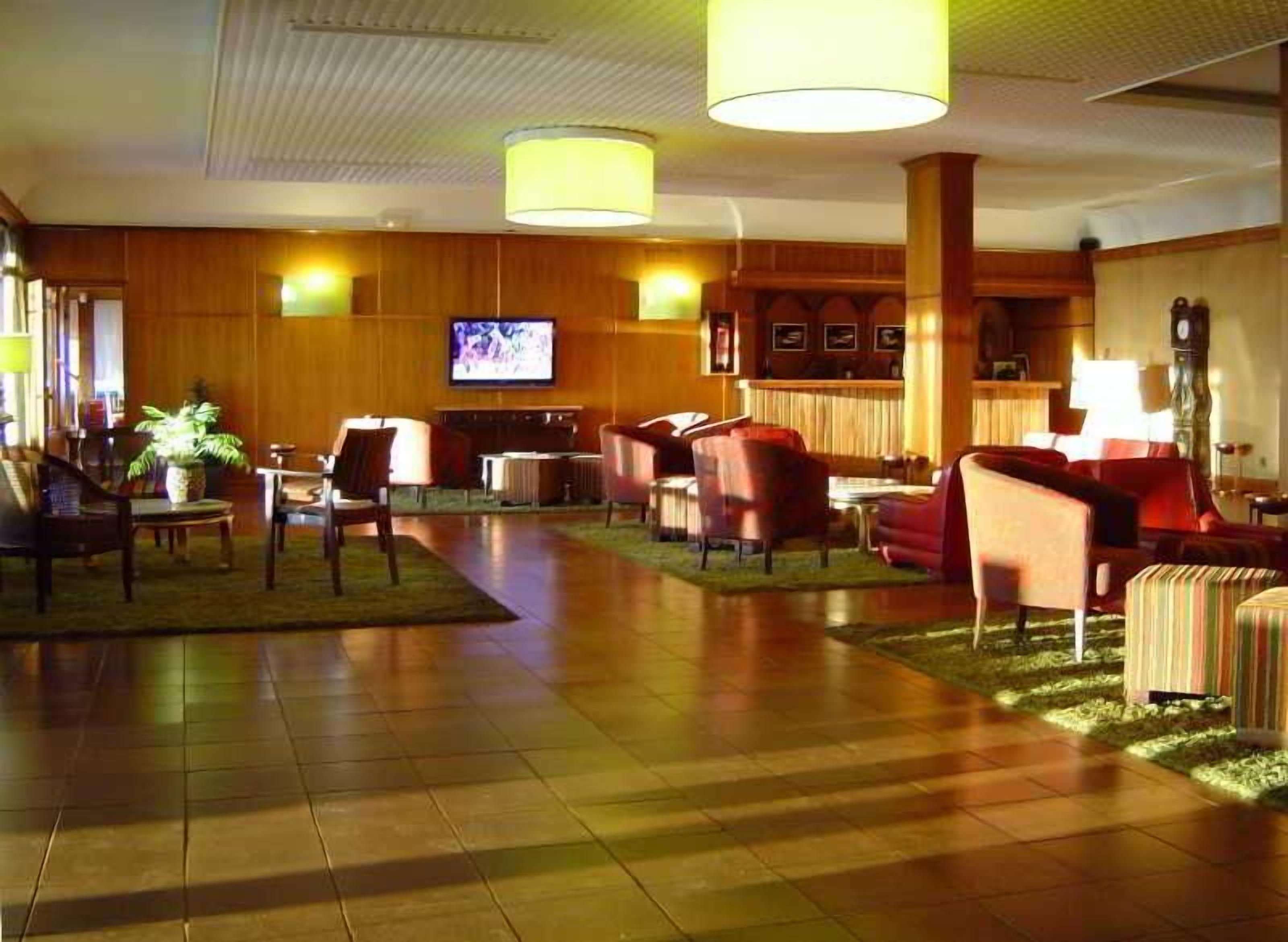 Un hall de hotel con televisión, zona de estar y chimenea.