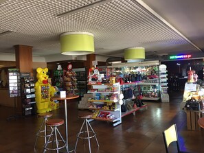 Una tienda minorista con una variedad de productos, incluyendo bocadillos y artículos de cuidado personal, y una gran figura de mascota.