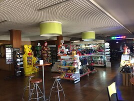 Una tienda minorista con una variedad de productos, incluyendo bocadillos y artículos de cuidado personal, y una gran figura de mascota.