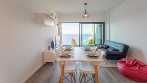 Ein modernes Wohnzimmer mit Essbereich, einer Couch und einem roten Sitzsack.